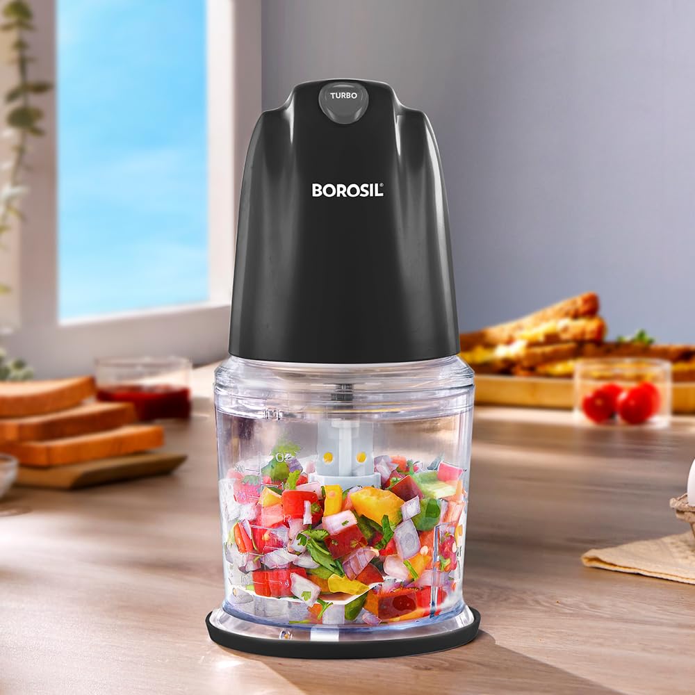 Borosil electric mini chopper with a transparent bowl filled with freshly chopped vegetables, featuring a turbo button and compact countertop design for quick food preparation.