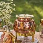 Paras 5L hammered copper water pot with dispensing tap, premium brass lid and brass stand, handcrafted copper water dispenser for storing and serving drinking water at home, office, and meditation centers.