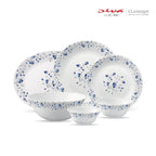 A 5-piece ceramic dinnerware set from Diva from D'Orsa in the Classique Collection, featuring white plates and bowls with a delicate blue floral pattern and scalloped edges, displayed on a clean white background.