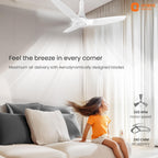 Living room with a ceiling fan and child enjoying the breeze, Orient Electric branding visible.