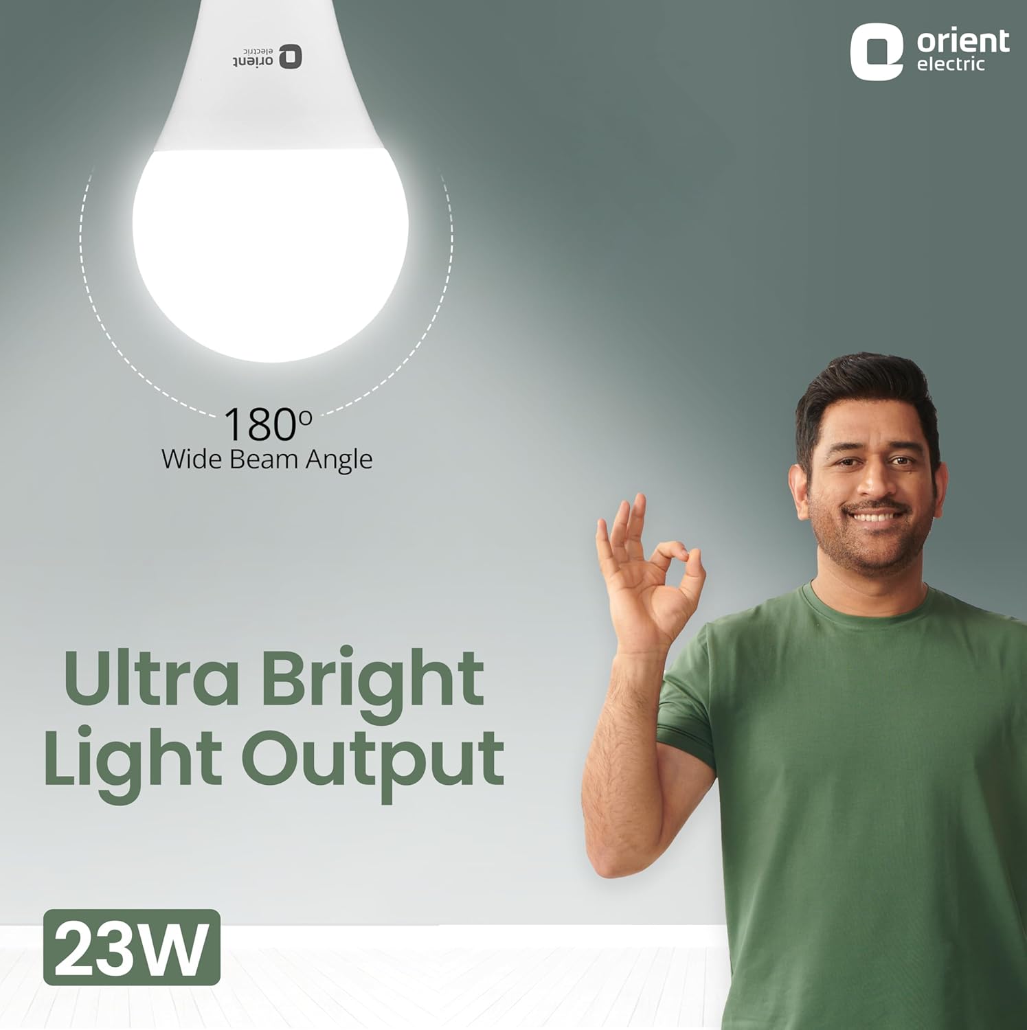Promotional graphic for an Orient Electric LED bulb showing a glowing bulb shape, text reading 'Ultra Bright Light Output' and '180° Wide Beam Angle,' plus a smiling man in a green shirt making an 'okay' gesture. The Orient Electric logo appears in the top right, and '23W' is shown in the bottom left.