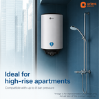 Orient Electric wall-mounted water heater in a blue tiled bathroom setting, shown next to a chrome shower fixture with text overlays stating 'Ideal for high-rise apartments' and 'Compatible with up to 8 bar pressure'.