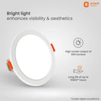 A white recessed LED downlight fixture by Orient Electric, shown at an angle with orange accent tabs on a light gray background. The image includes marketing text and icons highlighting 900 lumens output and up to 15000 hours of life.