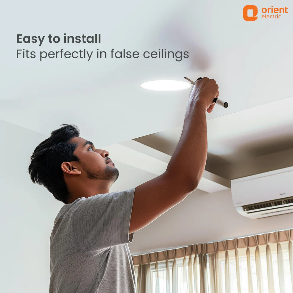 Person installing a light fixture in a ceiling with Orient Electric branding.