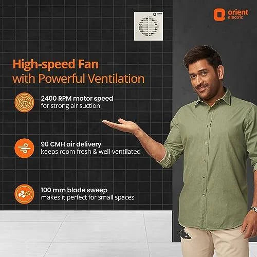 A man in a green shirt stands beside a dark promotional graphic for an Orient Electric high-speed fan, with text highlighting 2400 RPM motor speed, 90 cm air delivery, and 100 mm blade sweep.
